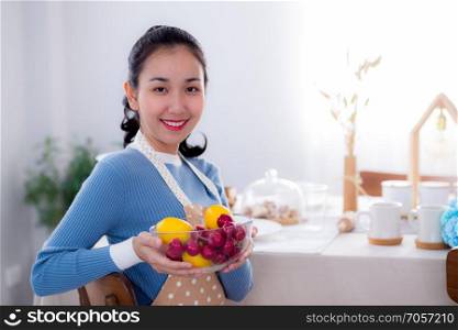 Pretty female holding bowl with a smile in kitchen