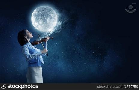 Pretty female violinist. Young woman playing violin and full moon in sky