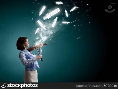 Pretty female violinist. Young woman playing violin and glowing light bulbs in air