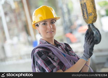 pretty female worker holding crane hook