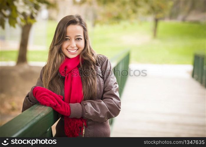 Pretty Festive Smiling Woman Portrait Wearing a Red Scarf and Mittens Outside.