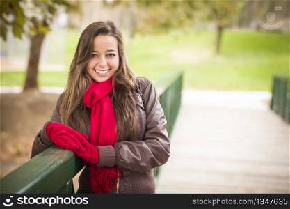 Pretty Festive Smiling Woman Portrait Wearing a Red Scarf and Mittens Outside.