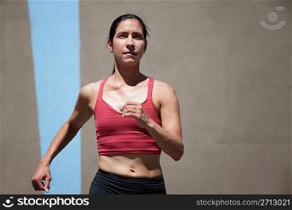 Pretty, focused woman runs to keep in shape.