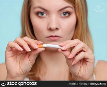 Pretty girl breaking up with cigarette. Addicted nicotine problems in young age. Quitting from addiction concept.. Girl breaking up with cigarette.