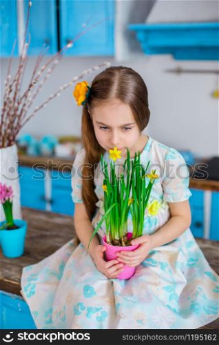 Pretty girl holding a pot of daffodil flowers in anticipation of spring and Easter. Festive mood.. Pretty girl holding a pot of daffodil flowers in anticipation of spring and Easter.