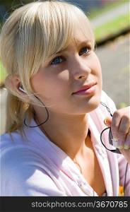pretty girl in sportwear listening music from mp3 in a sunny day outdoor