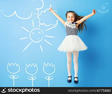 Pretty girl making chalk drawings on the wall