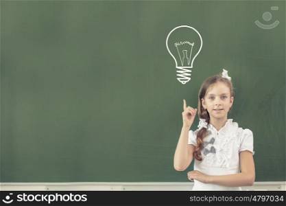 Pretty girl of school age standing at blackboard. Back to school