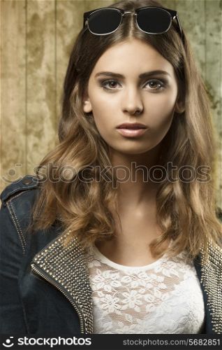 pretty girl posing in close-up fashion shoot with sunglasses on the head, wavy natural hair-style and casual autumn style.