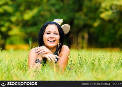 Pretty girl relaxing outdoor on green grass