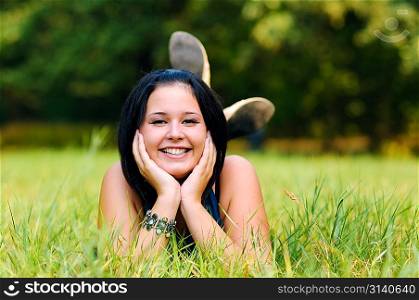 Pretty girl relaxing outdoor on green grass