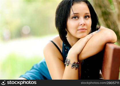 Pretty girl siiting on a bench in a park