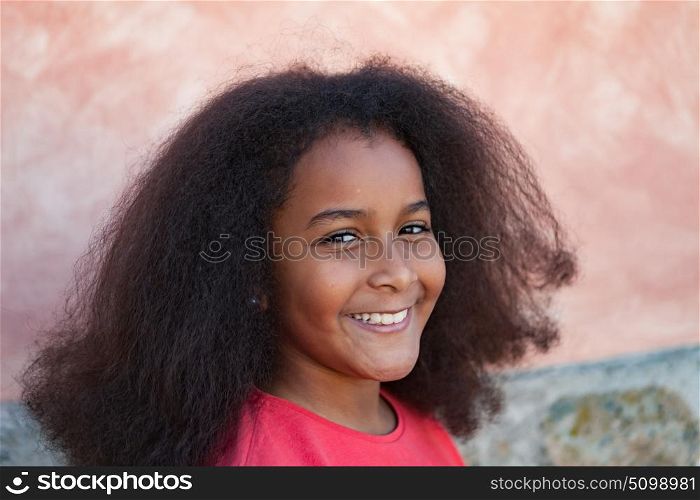 Pretty girl with long afro hair in the garden laughing