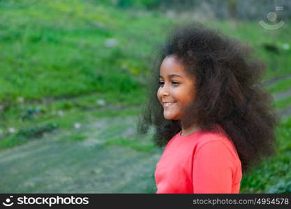 Pretty girl with long afro hair in the garden with a blue coat