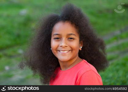 Pretty girl with long afro hair in the garden with a blue coat