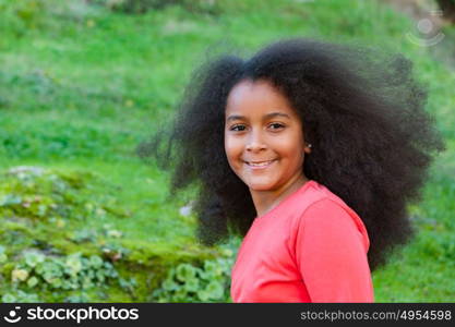 Pretty girl with long afro hair in the garden with a blue coat