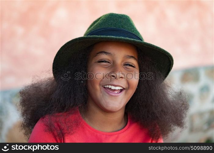 Pretty girl with long afro hair in the garden with a elegant black hat