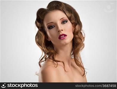 pretty girl with long wavy hair and purple make-up, she looks in to the lens with sensual expression