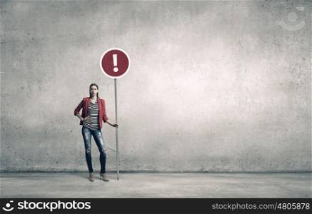 Pretty girl with roadsign. Young woman in red jacket holding road sign