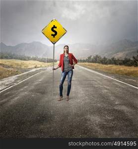 Pretty girl with roadsign. Young woman in red jacket holding yellow road sign