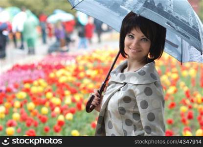 Pretty girl with umbrella in the garden