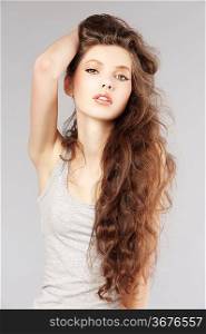 pretty girl with very long curly hair in a fashion portrait looking in camera