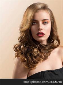 pretty girl with wavy hair and red lipstick, she is in front of the camera and looks in to the lens