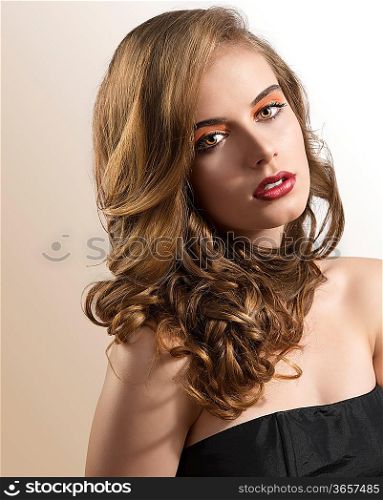 pretty girl with wavy hair and red lipstick, she is turned of three quarters at left with folded head and looks in the lens