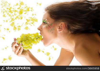 pretty girl with windly hair eating grape with a nice body paint on her face