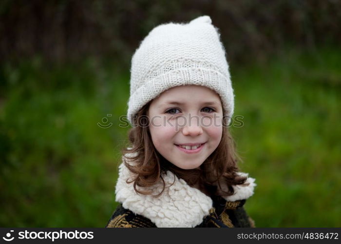 Pretty girl with wool hat in a park at winter