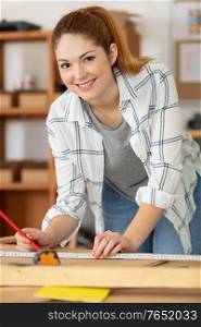 pretty hardworking carpenter woman at workplace