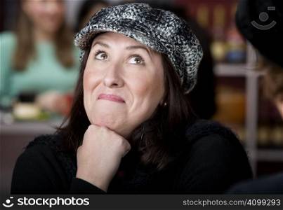 Pretty Hispanic woman in hat with funny expression