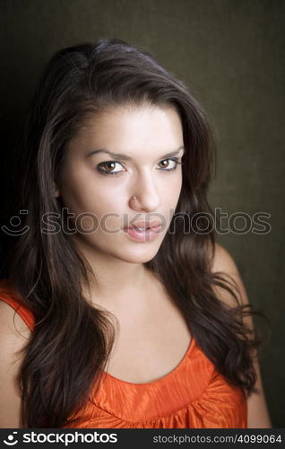 Pretty Hispanic woman in orange on green background