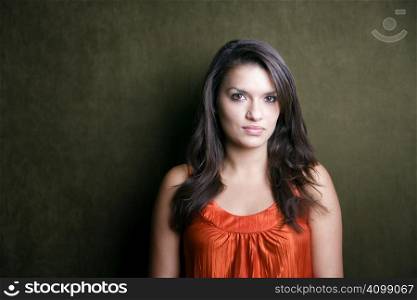 Pretty Hispanic woman in orange on green background