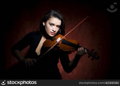 Pretty Hispanic woman in studio playing a violin