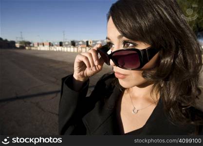 Pretty Hispanic woman with dark sunglasses in an urban setting