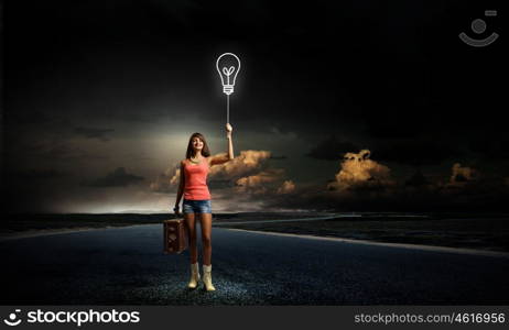 Pretty hitchhiking girl. Young retro woman with balloon and her retro baggage in hand