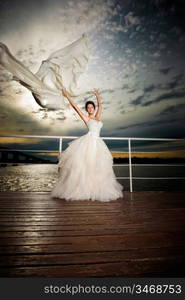 Pretty lady in a wedding dress on deck.