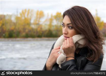 Pretty Latino woman outdoors on a cold day looking away from the camera