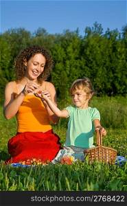 pretty Little Girl and Young Women keeps in hand sweet cherries on picnic