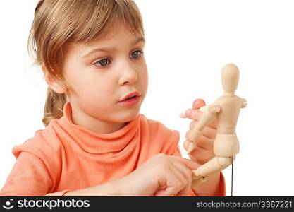pretty little girl is played by wooden little manikin isolated on white background, steadfastly looking at manikin