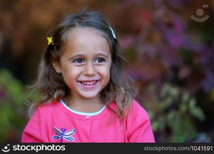 Pretty little girl with big eyes smiling, outdoor