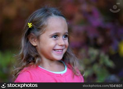 Pretty little girl with big eyes smiling, outdoor