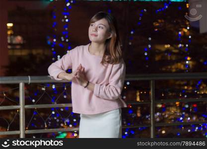 Pretty Malaysian female with blue lights behind her