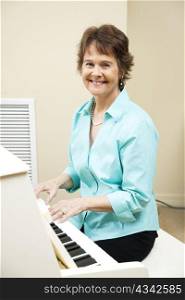 Pretty mature woman enjoys playing piano at her church.