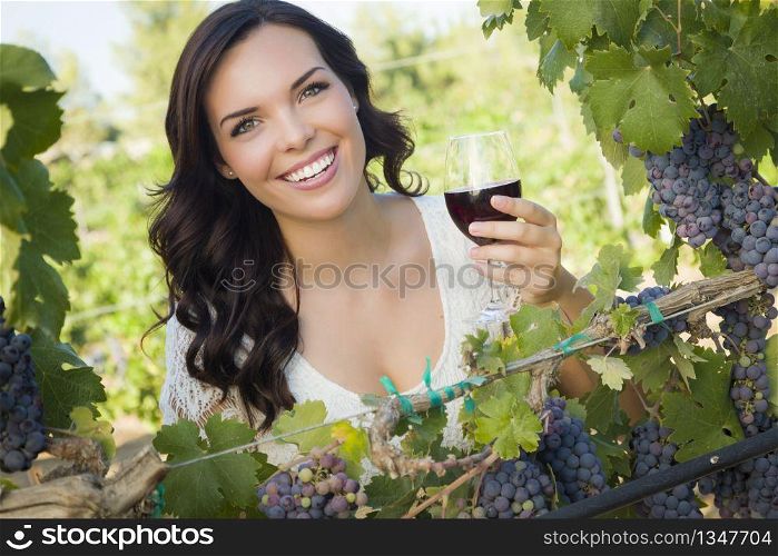 Pretty Mixed Race Young Adult Woman Enjoying A Glass of Wine in the Vineyard.