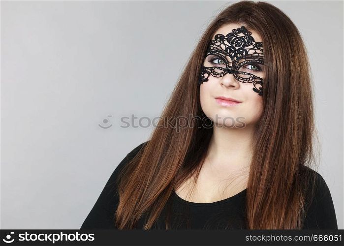 Pretty mysterious woman wearing black eye lace mask having long brown hair.. Mysterious woman wearing lace mask