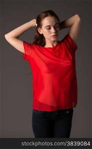 Pretty pale redhead in a red blouse and jeans