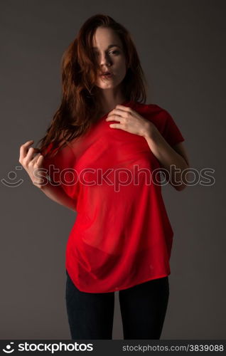 Pretty pale redhead in a red blouse and jeans