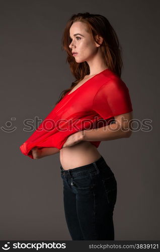 Pretty pale redhead in a red blouse and jeans